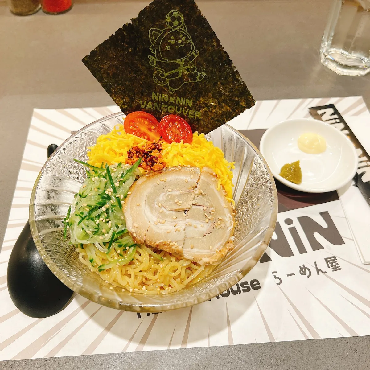 Ramen bowl with chashu, cucumber, tomatoes, and nori