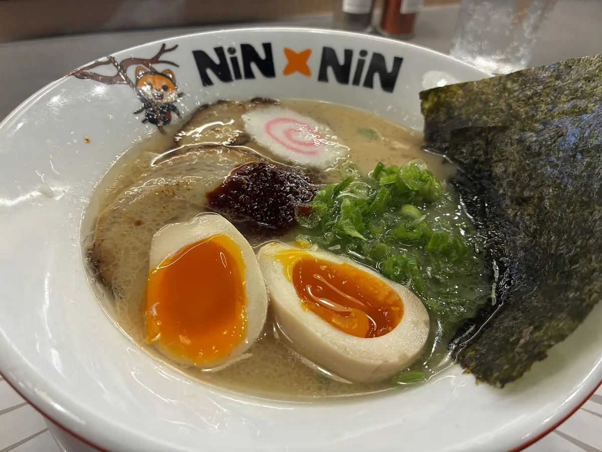 Ramen bowl with soft-boiled eggs, pork, and green onions