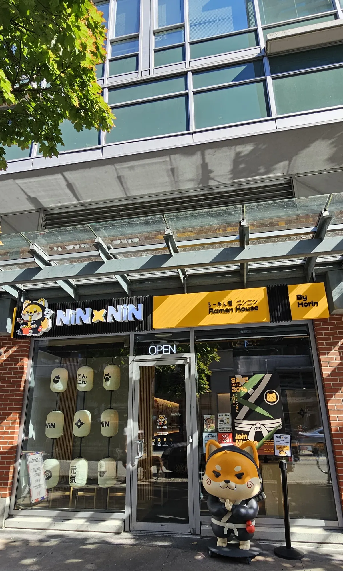 Ramen restaurant storefront with dog statue and lanterns